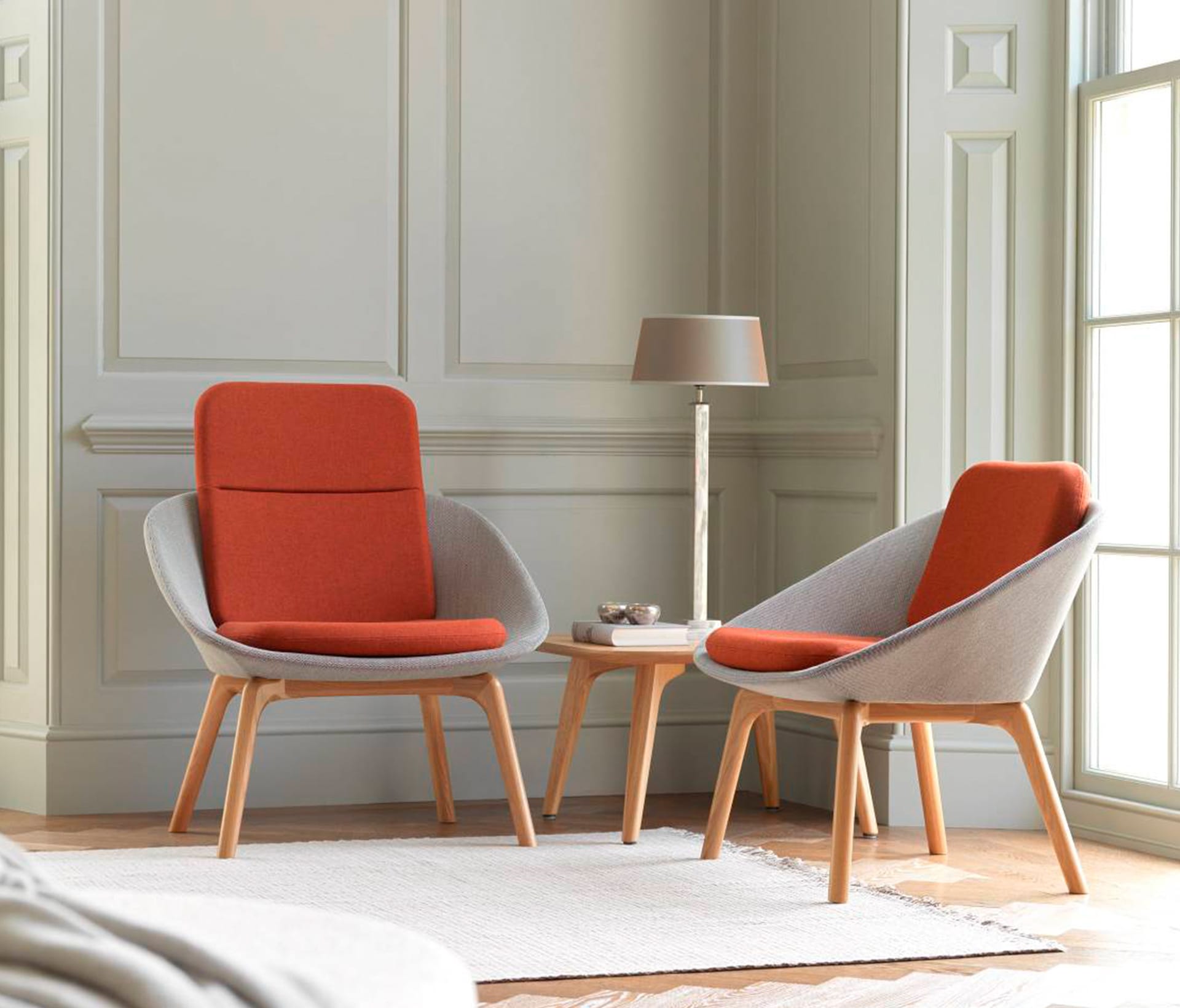 Two orange and grey lounge chairs for offices in a room.