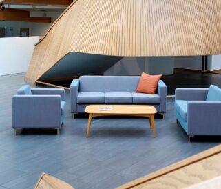 Three blue office sofas and a coffee table in a lobby.