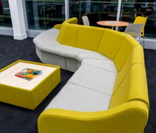 A yellow modular seating sofa in a room with a table.
