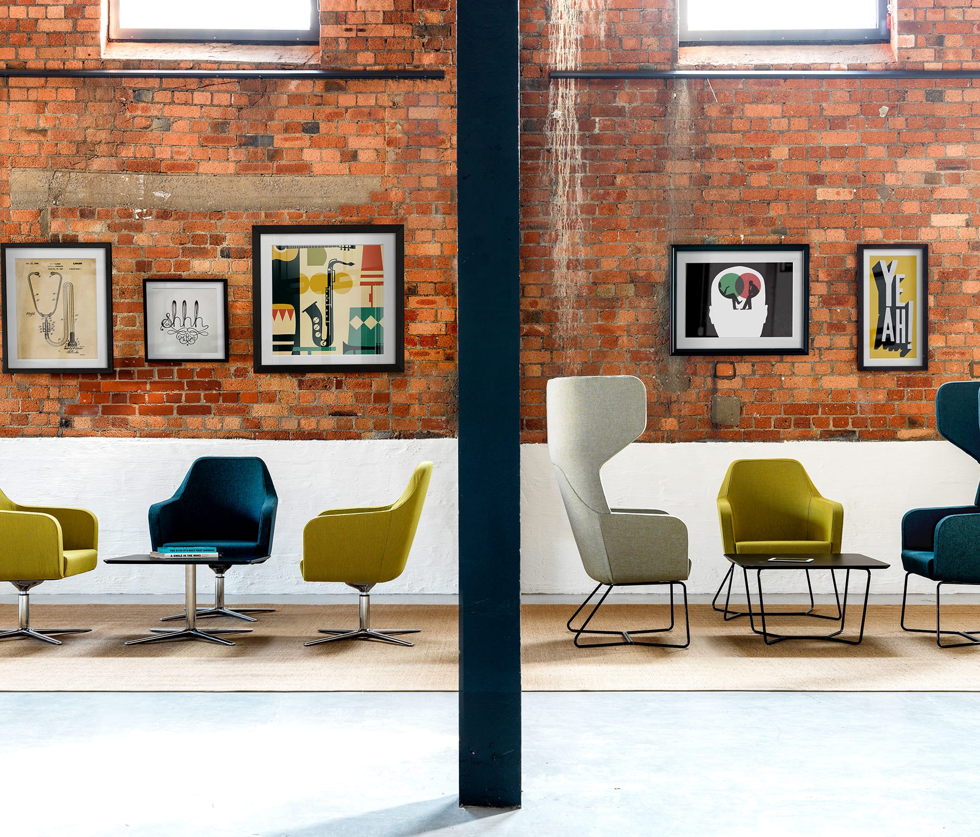 A group of office lounge chairs in a room with a brick wall.