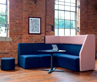 A blue and pink office corner sofa in a room with a table.