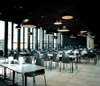 A large dining room with black tables and chairs.