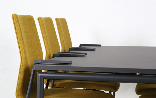 A black and yellow dining table with four yellow chairs.