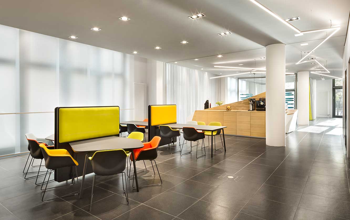 A brightly coloured office with tables and chairs.