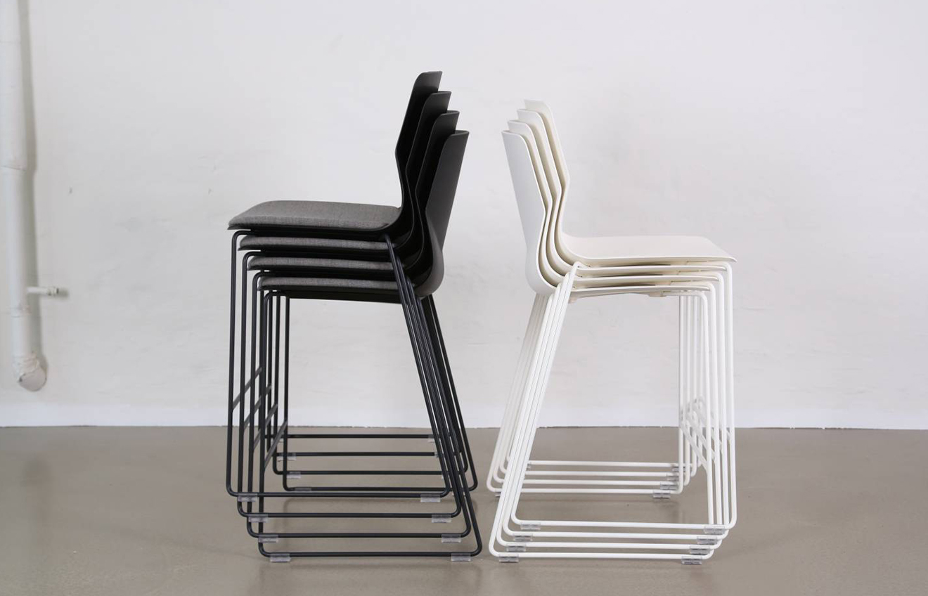 two piles of stacked chairs, one black one white
