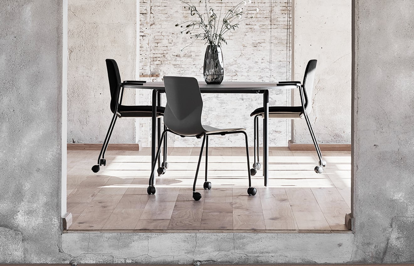 A dining room with a table and meeting table chairs