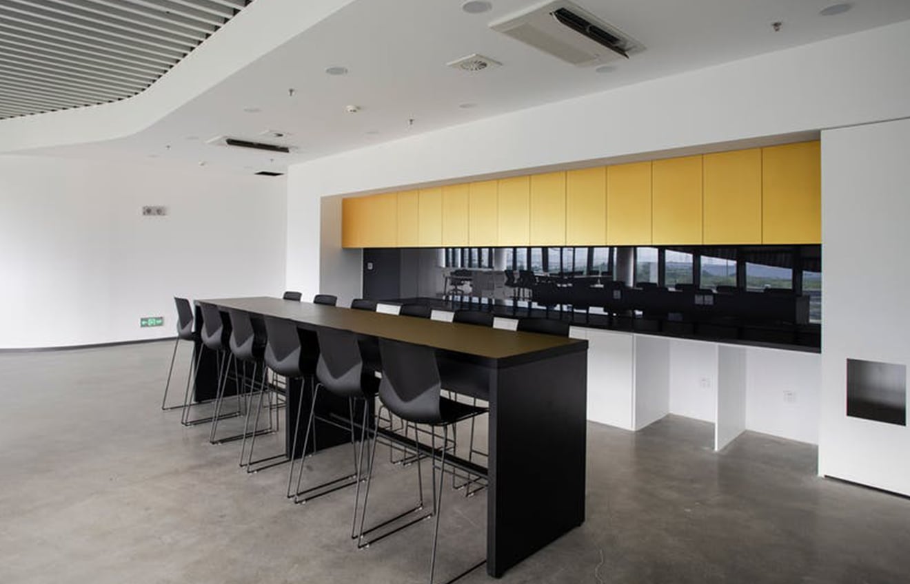 A modern office with black and yellow counter chairs