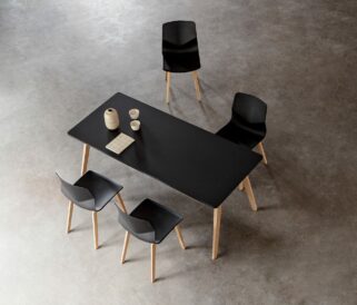 A black table with four black office desk chairs.