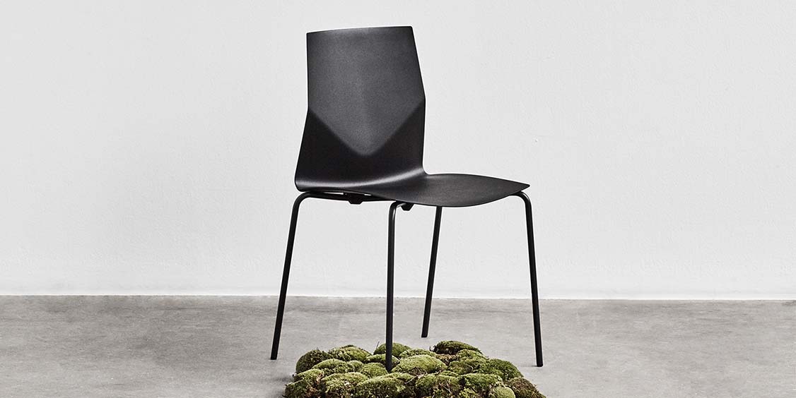 A black chair with moss under it