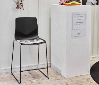 a counter chair with black seat and two legs