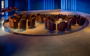 A circle of chairs in a circular room with blue lights.