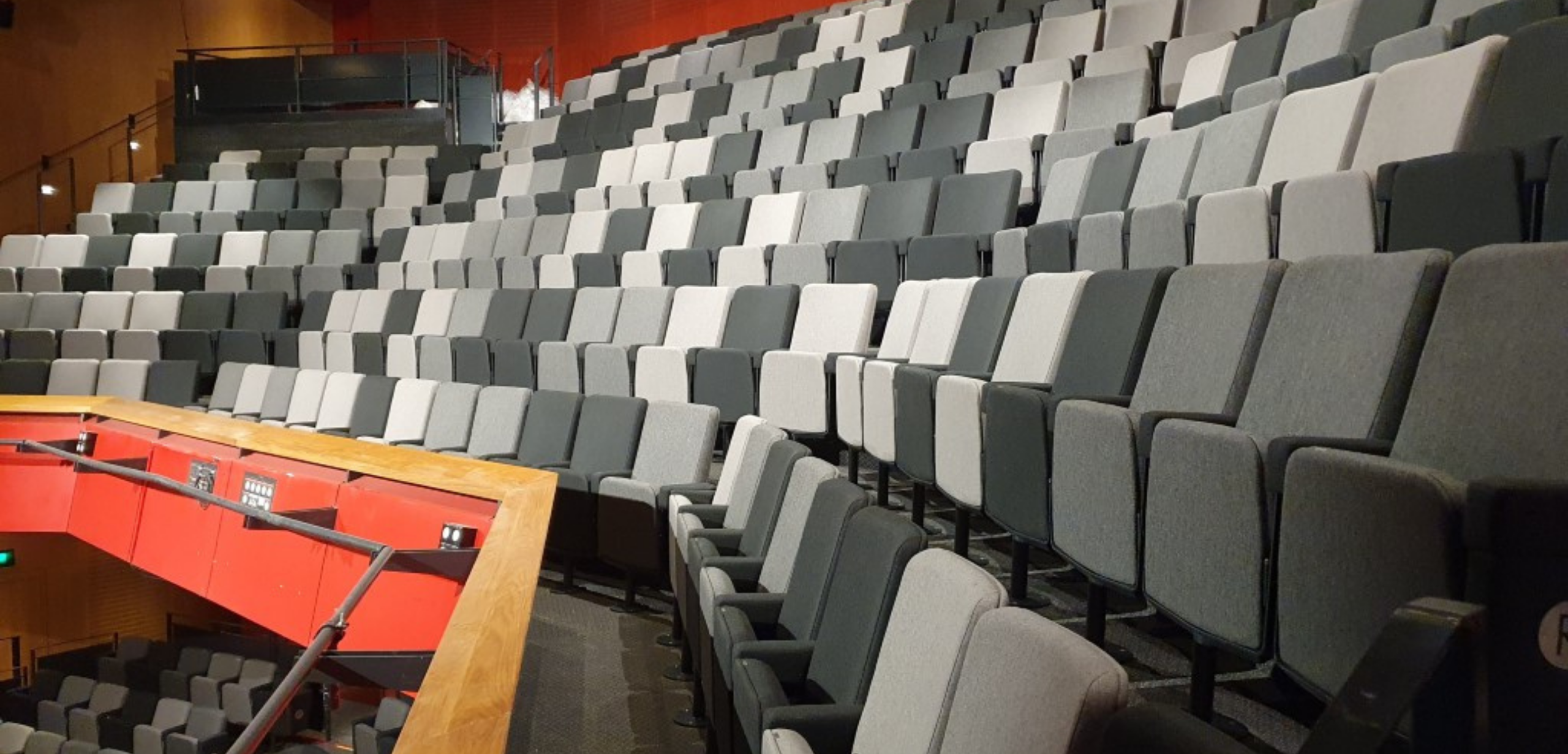 A large auditorium with a grey and white auditorium seating design