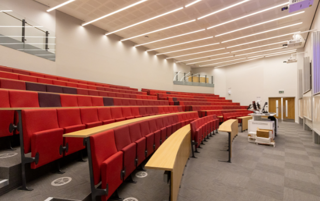 A large auditorium with red lecture hall seating