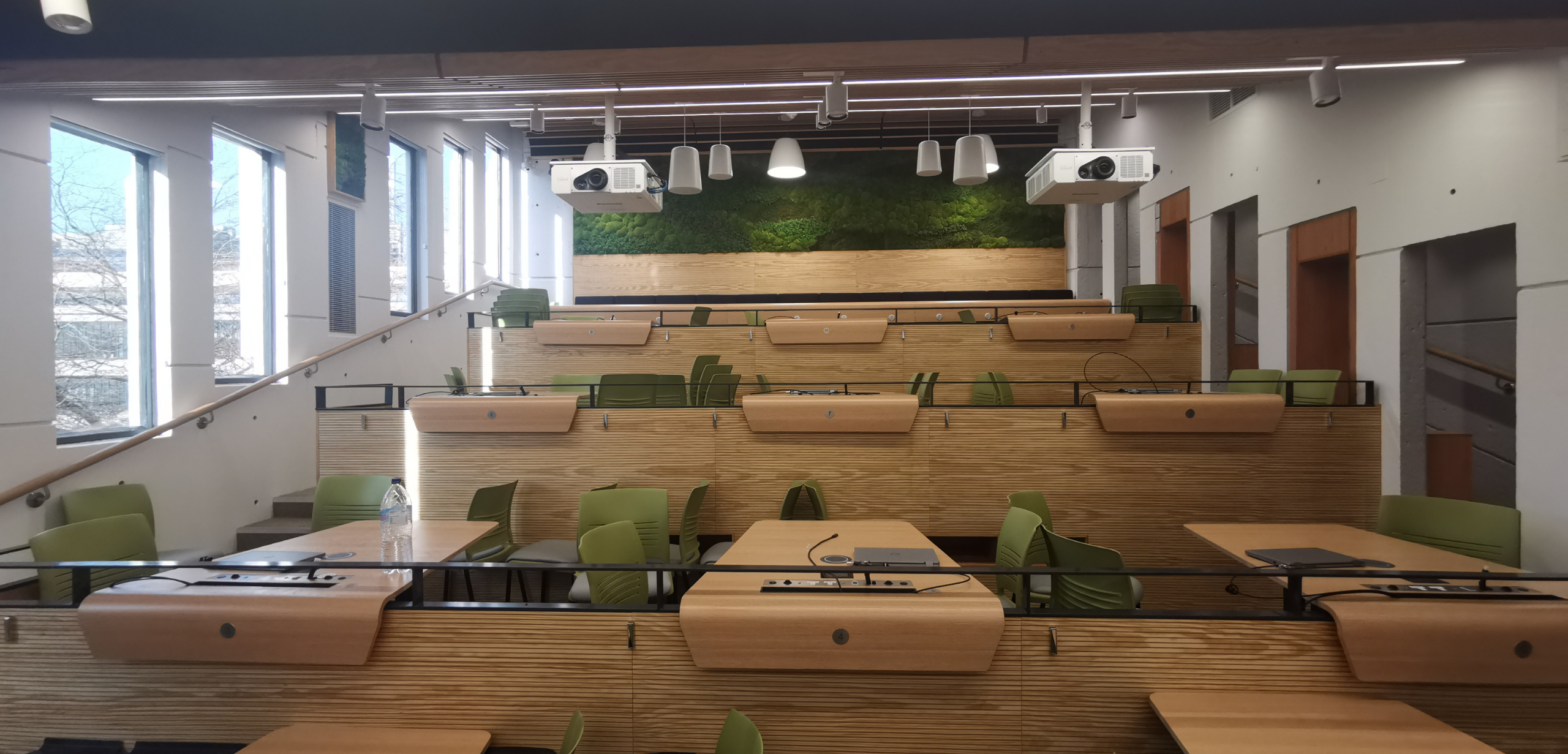 A lecture hall with green lecture hall seating and green walls.