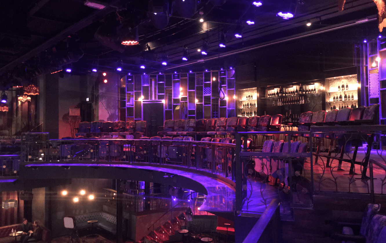 The inside of a nightclub with purple lighting.