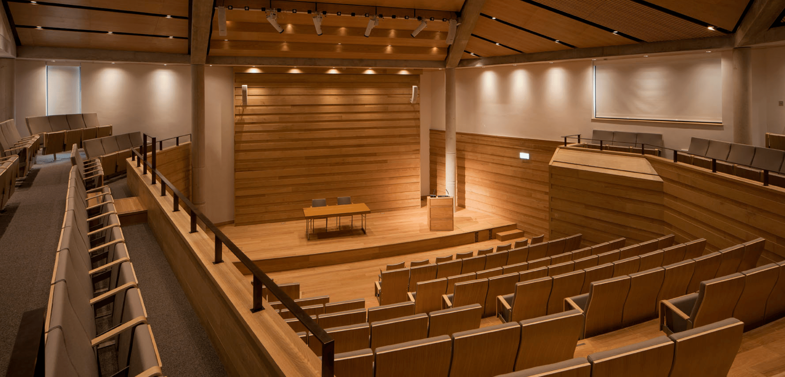 An auditorium with wooden tiered seating and a wooden ceiling.