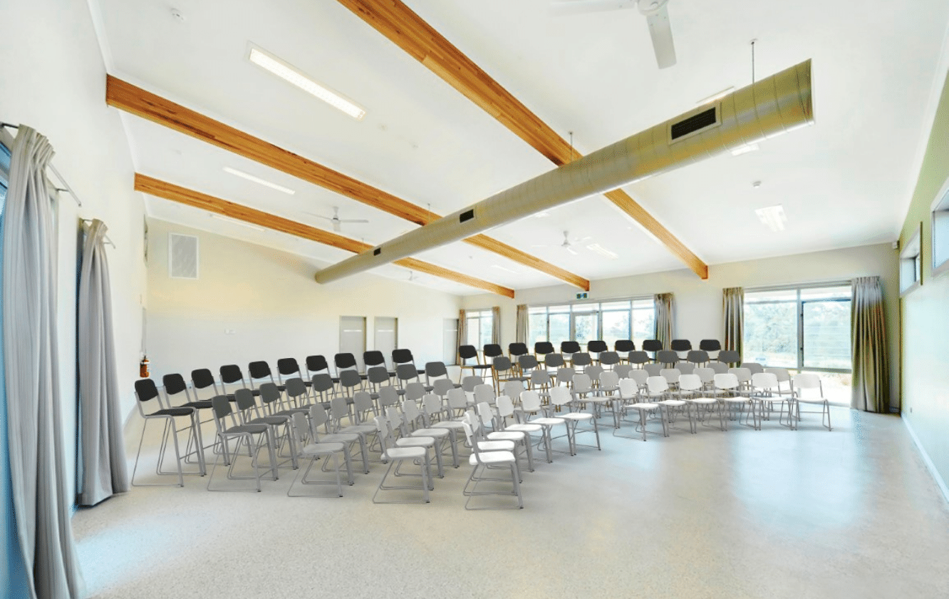 A large room with rows of chairs and a ceiling.