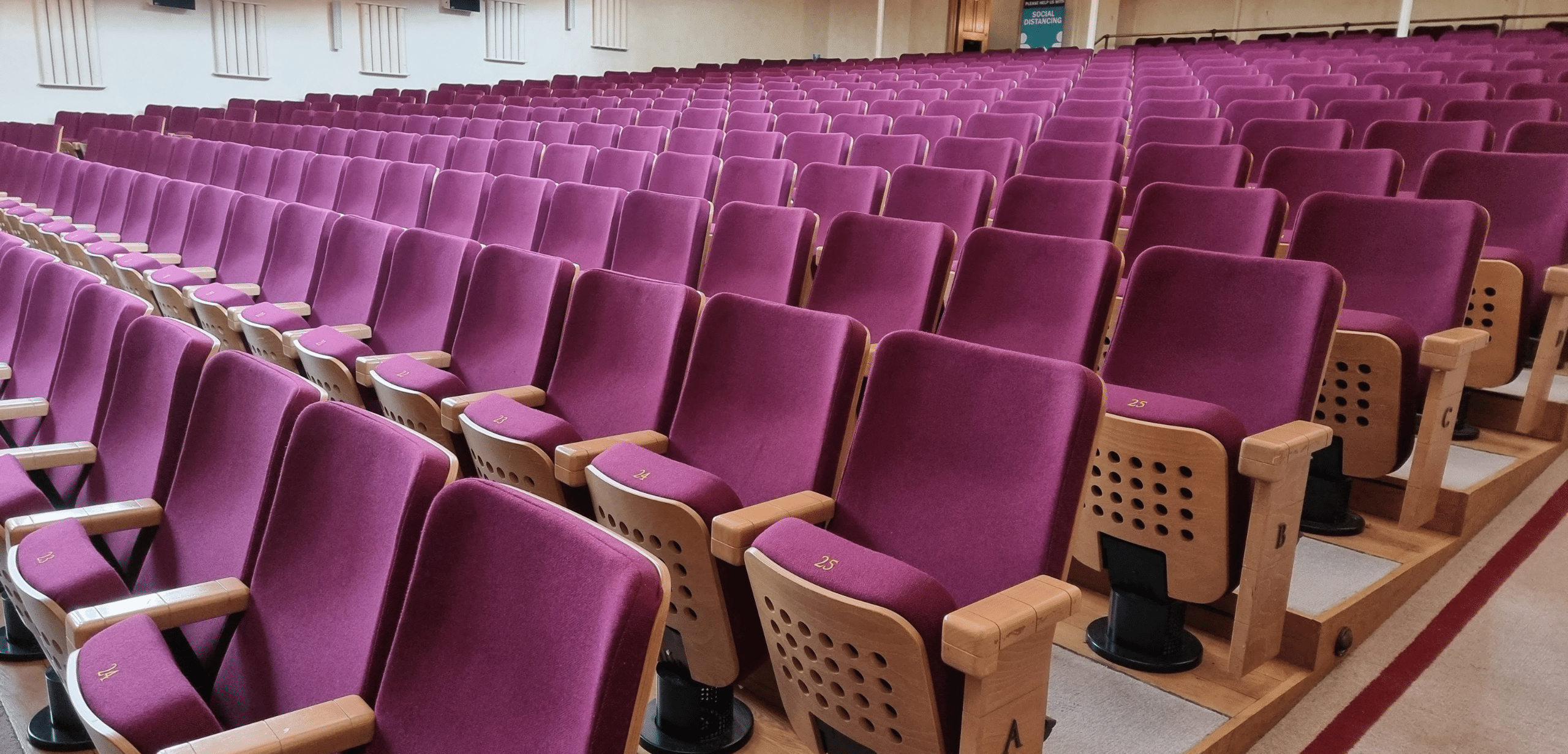 A large auditorium with rows of purple auditorium seating