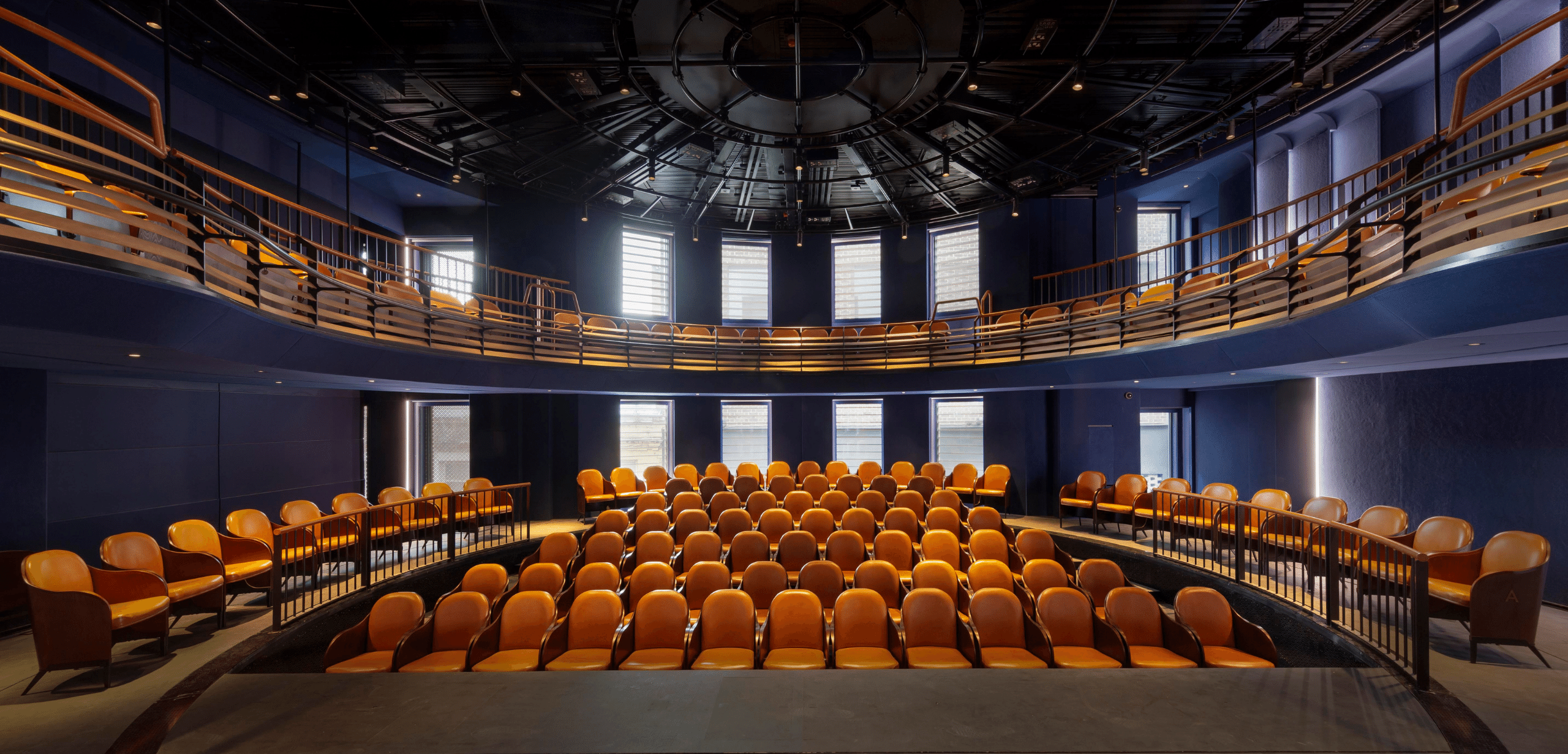 An auditorium with rows of auditorium seating and a circular ceiling.