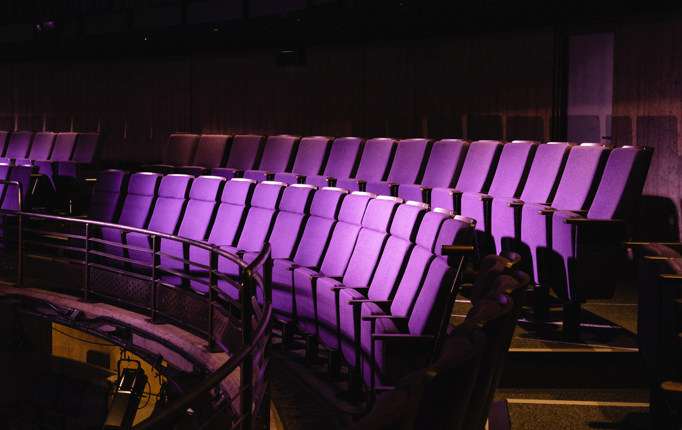 A row of purple auditorium seating in an auditorium.