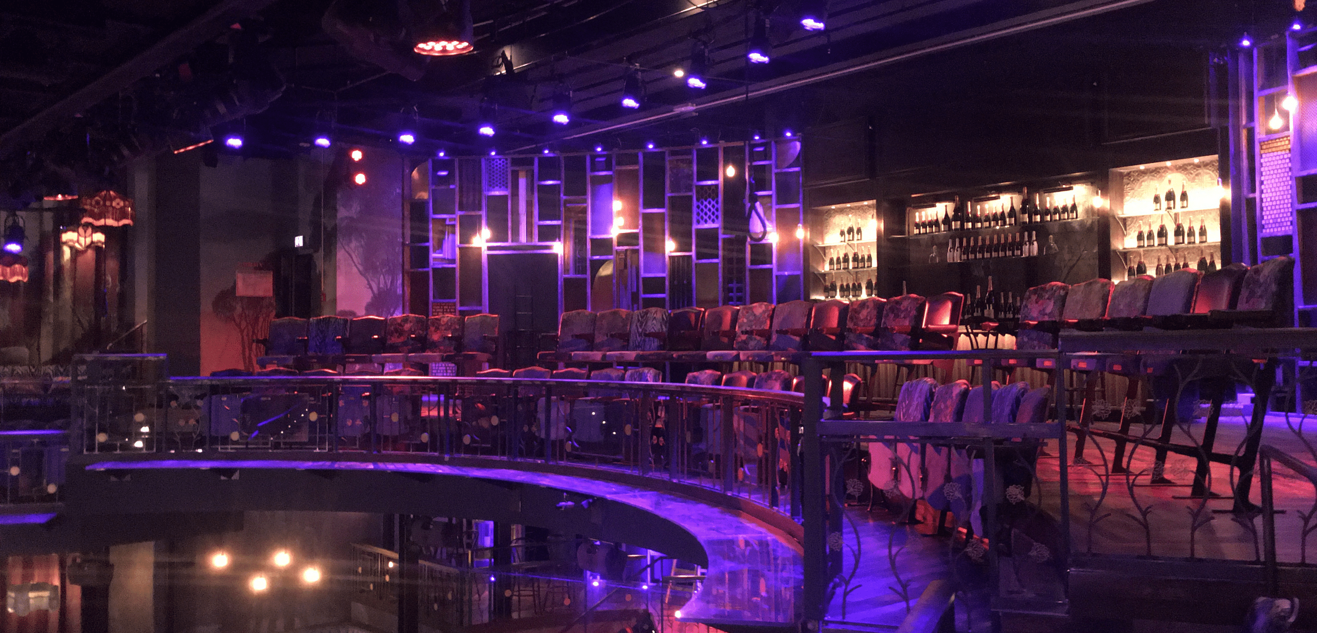 The interior of a bar with purple lighting.