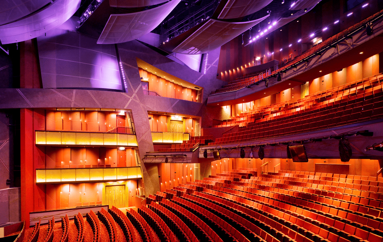 A large auditorium with red and purple auditorium seating