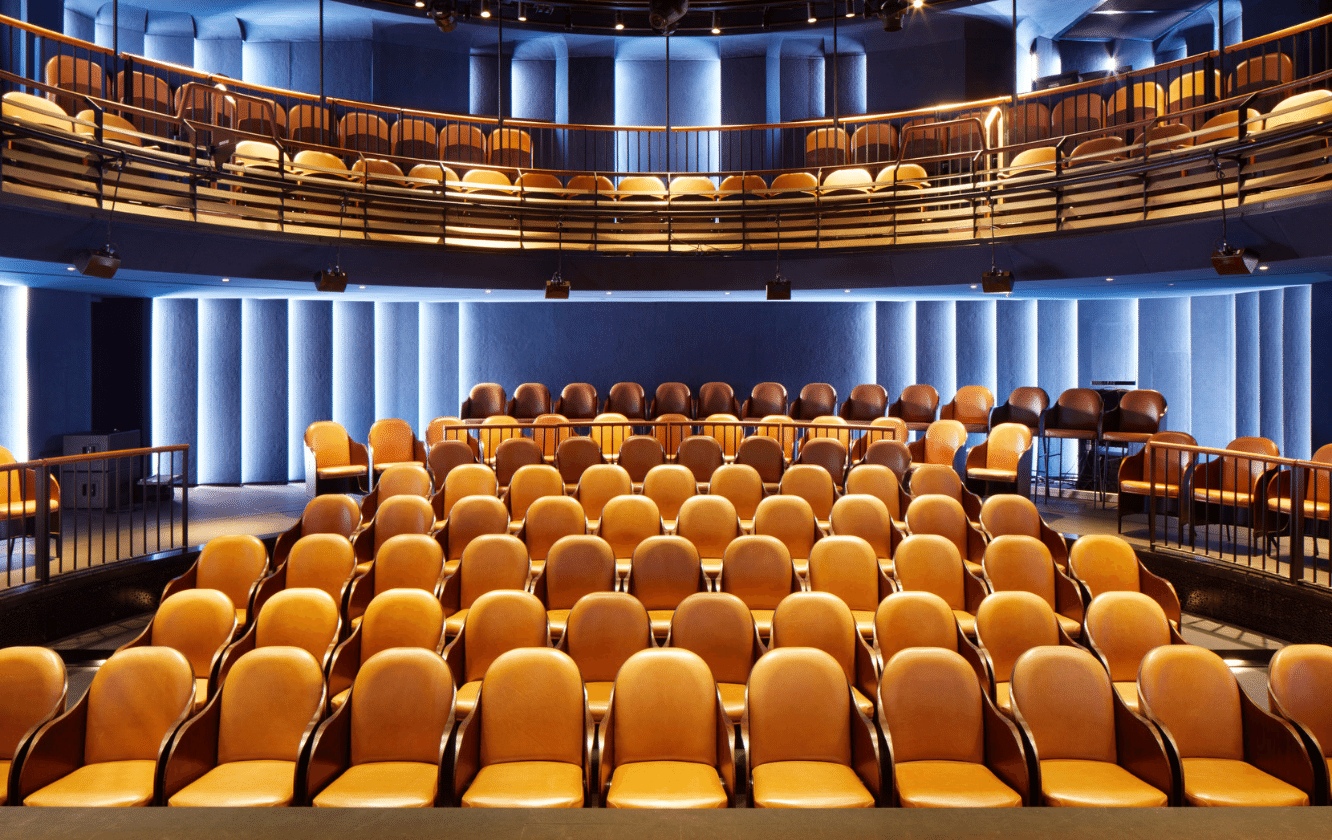 A large auditorium with rows of yellow auditorium seating