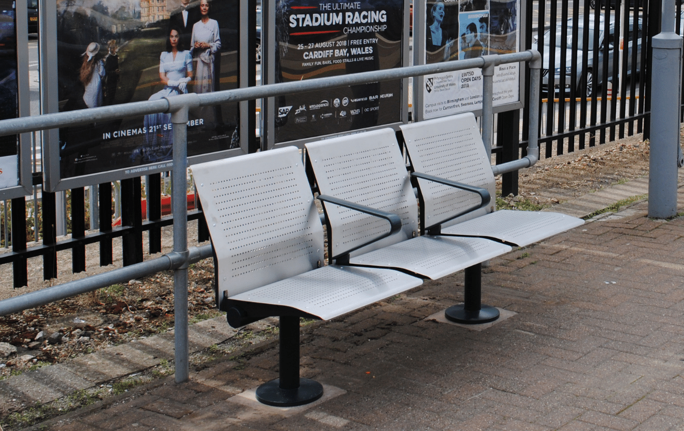 3 metal chairs on a train station platform