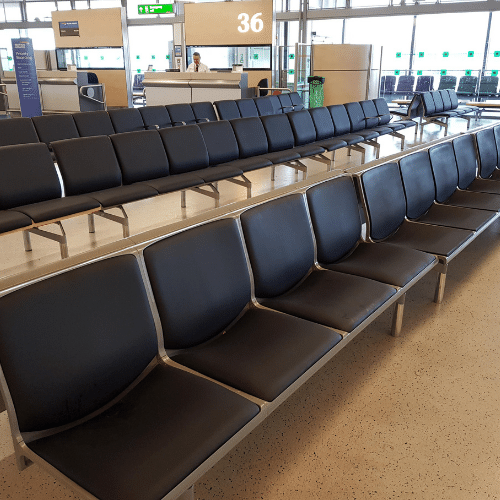 A row of black terminal seating in an airport.