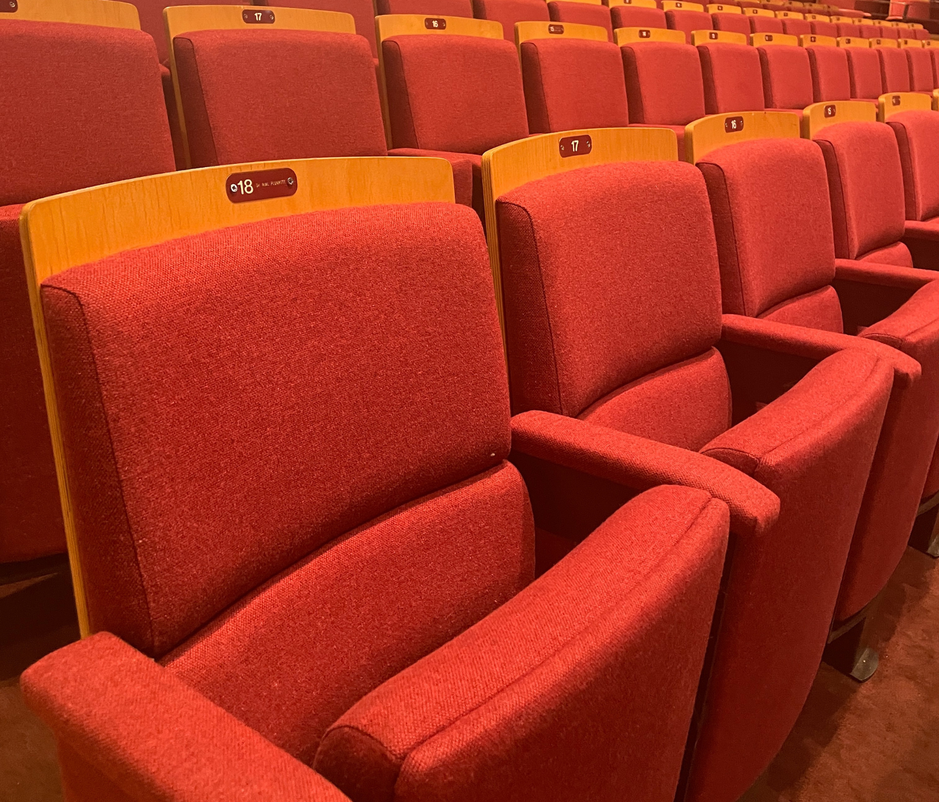 Rows of red tiered seating in an auditorium.