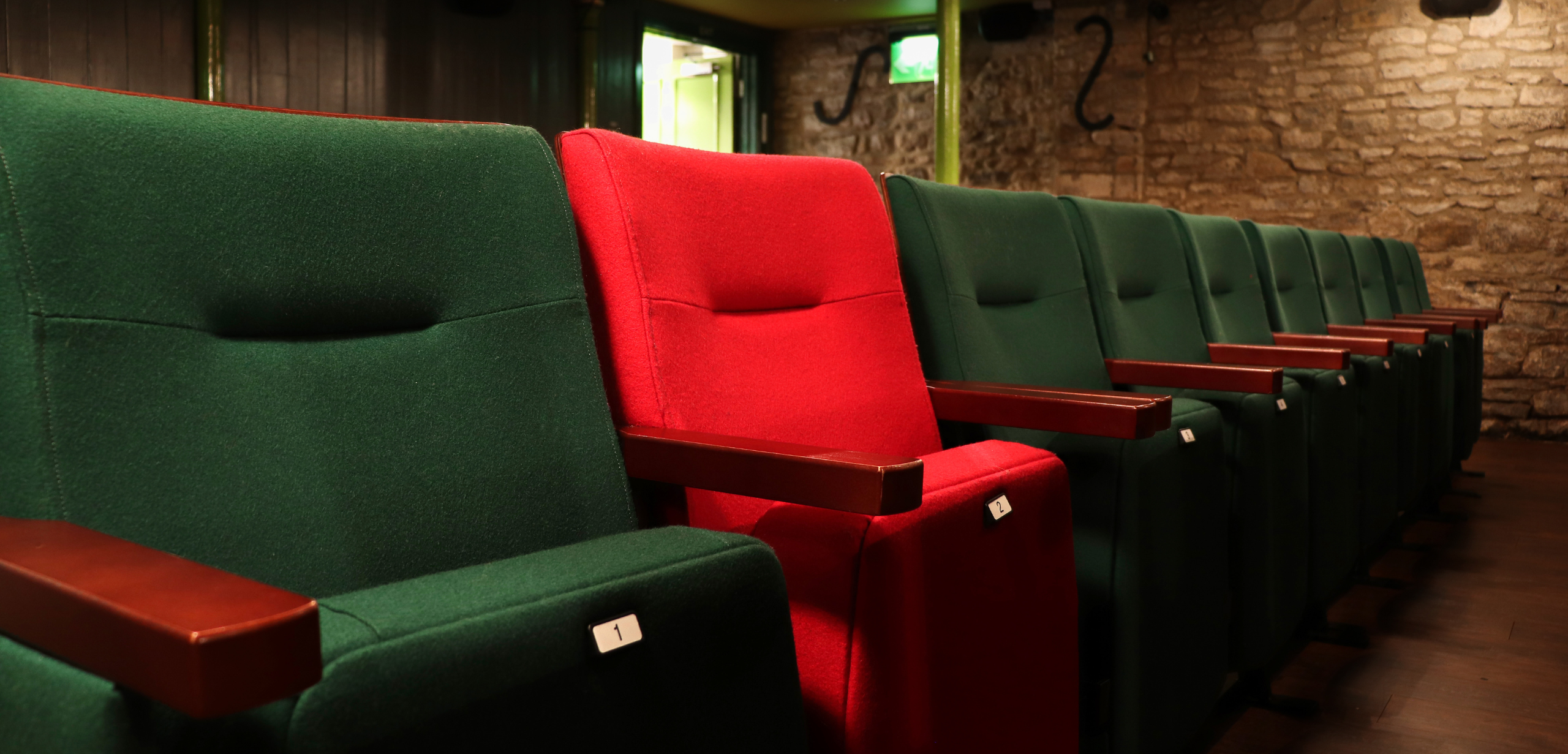 A row of red and green theater style seating.
