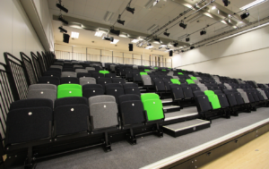 A large auditorium with rows of tiered seating and stairs.