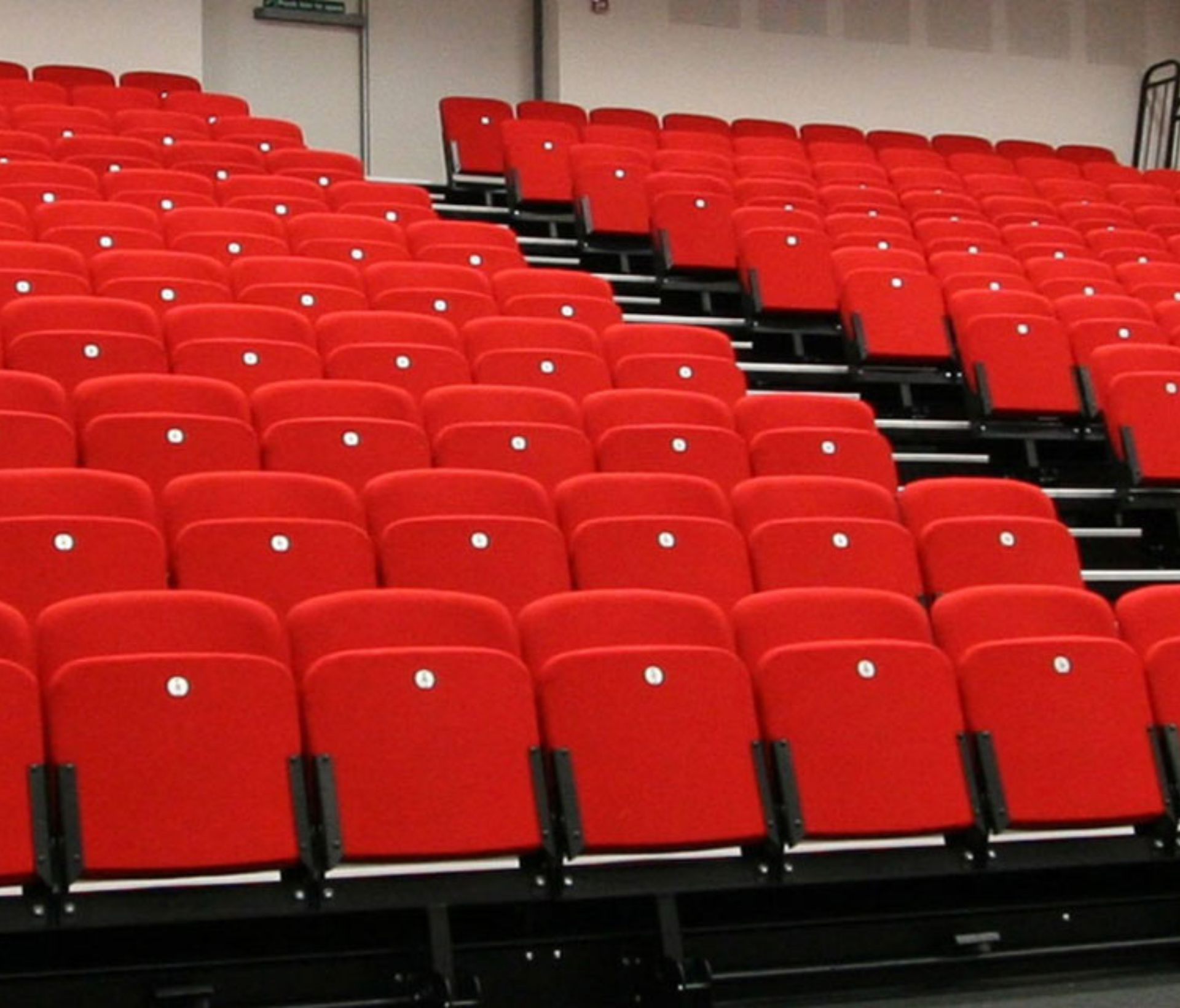 A large auditorium with rows of tiered seating and stairs.