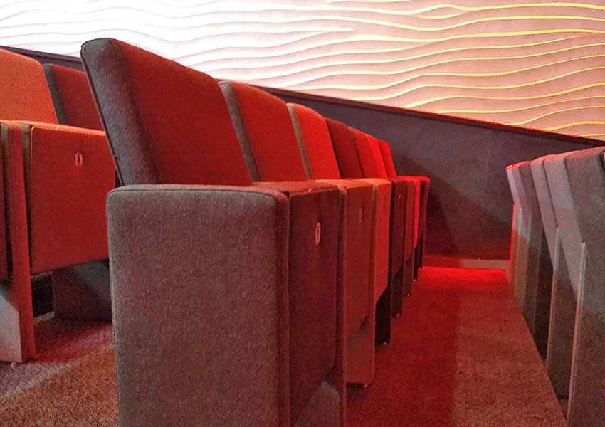 A row of tip up seating in an auditorium.