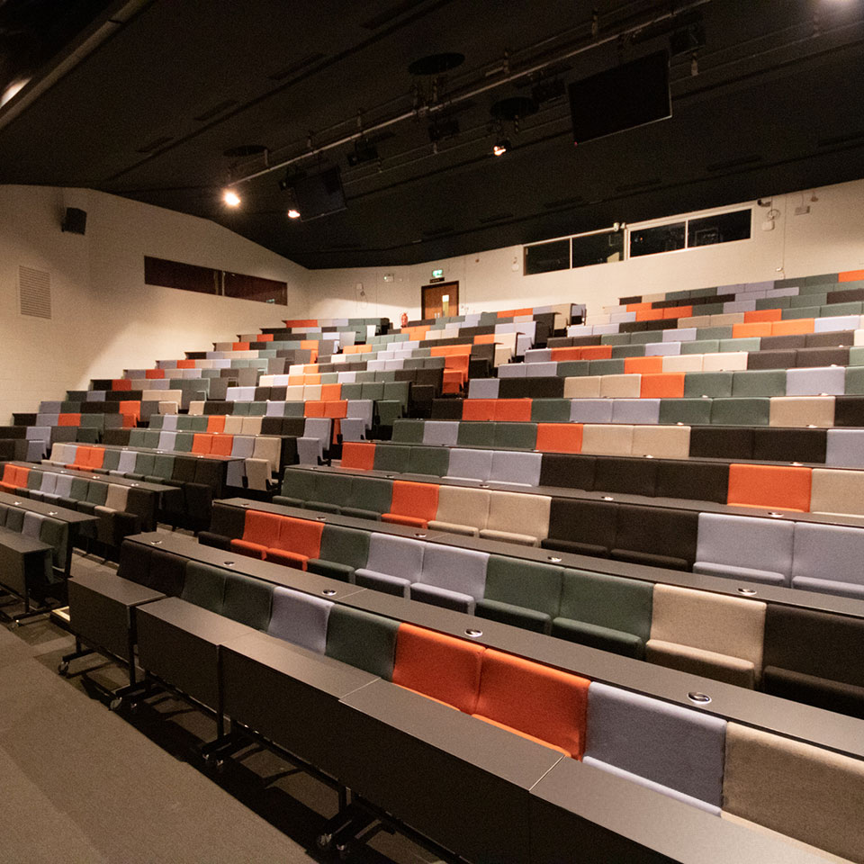 A lecture hall with rows of auditorium seating