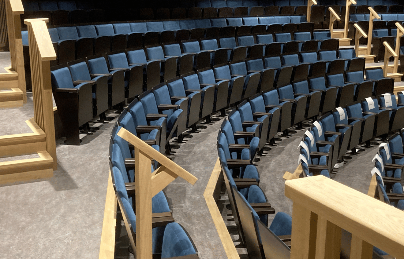 rows of blue seats in an auditorium